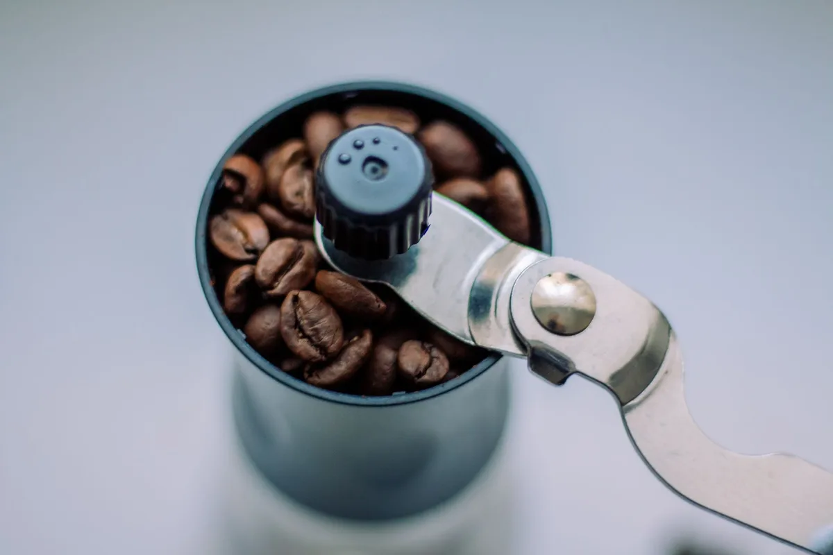 Différents appareils pour préparer le café : moulin, machine expresso et cafetière à piston
