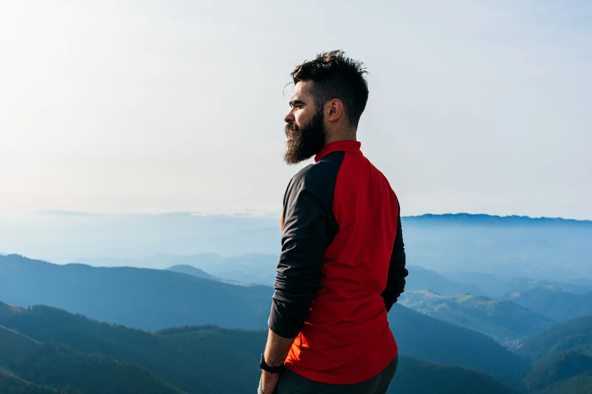 Personne portant des vêtements clairs et couvrants pour une randonnée en forêt, mesure de prévention contre les tiques.