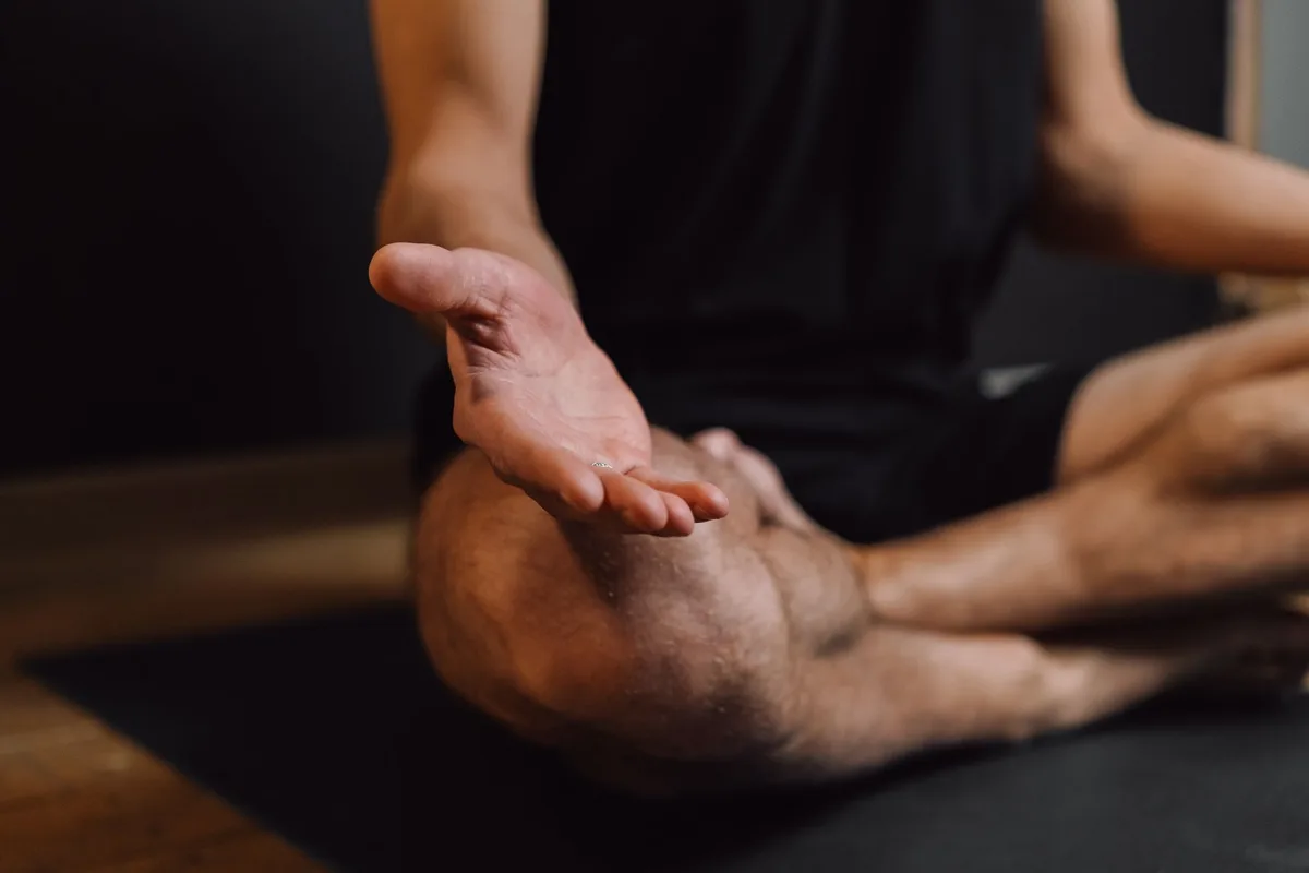 Personne en posture de méditation ou de pleine conscience dans un environnement calme