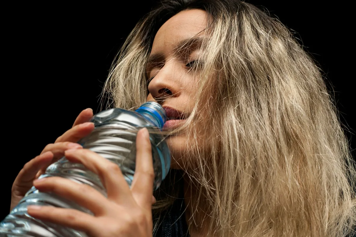 Personne buvant de l'eau pour rester bien hydratée