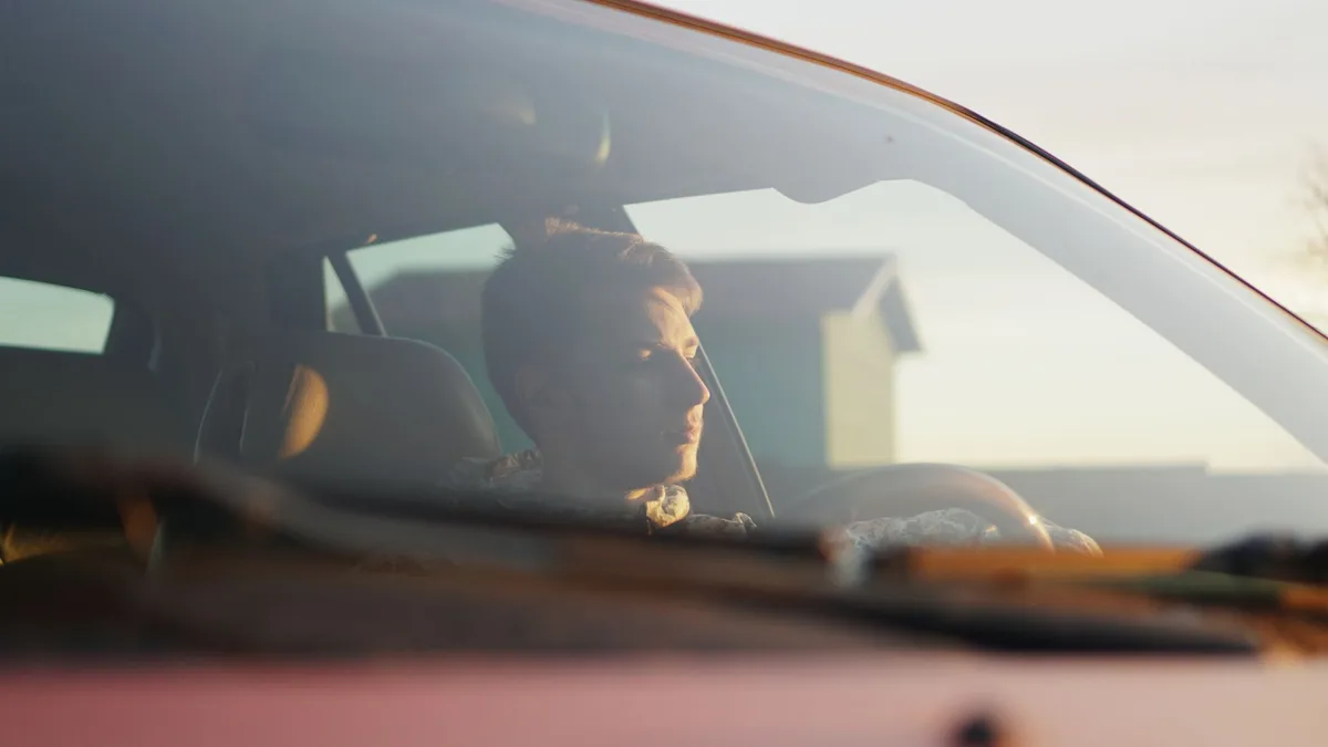Conducteur respirant profondément et calmement dans sa voiture pour gérer le stress
