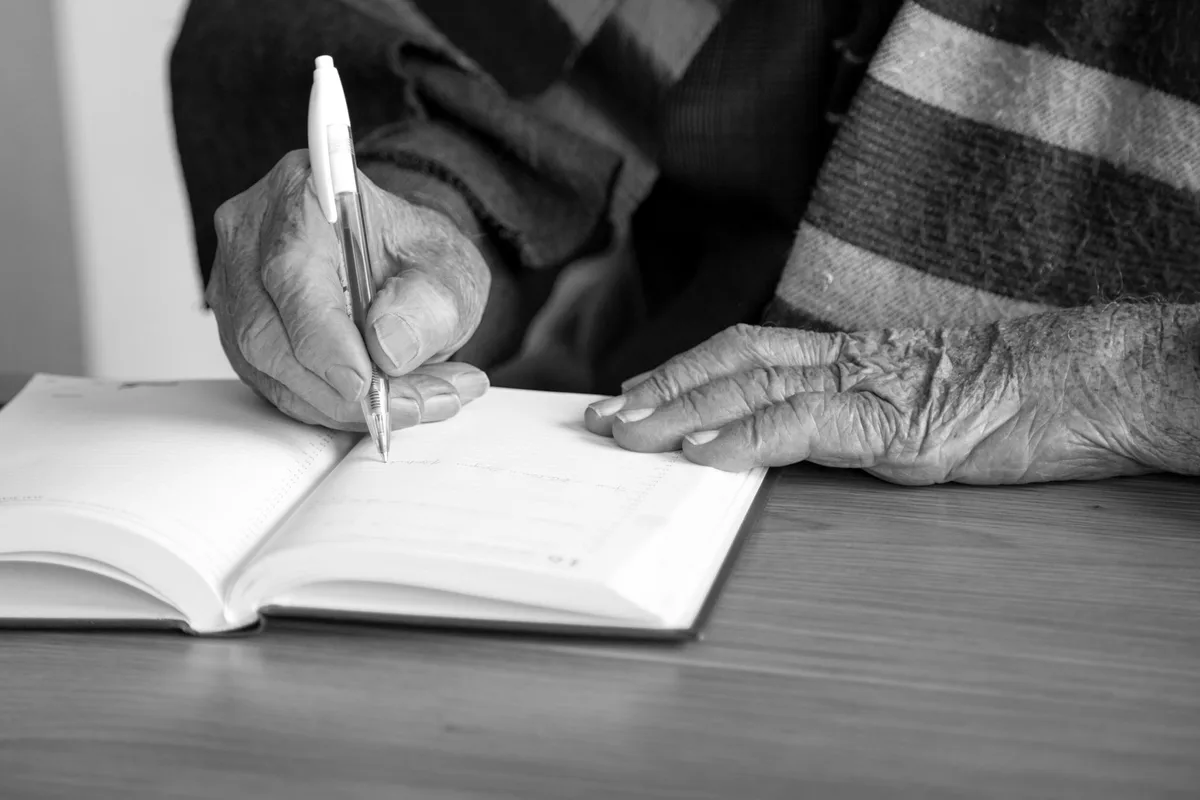 Mains d'une personne âgée accomplissant une tâche quotidienne, illustrant les adaptations face aux troubles cognitifs.