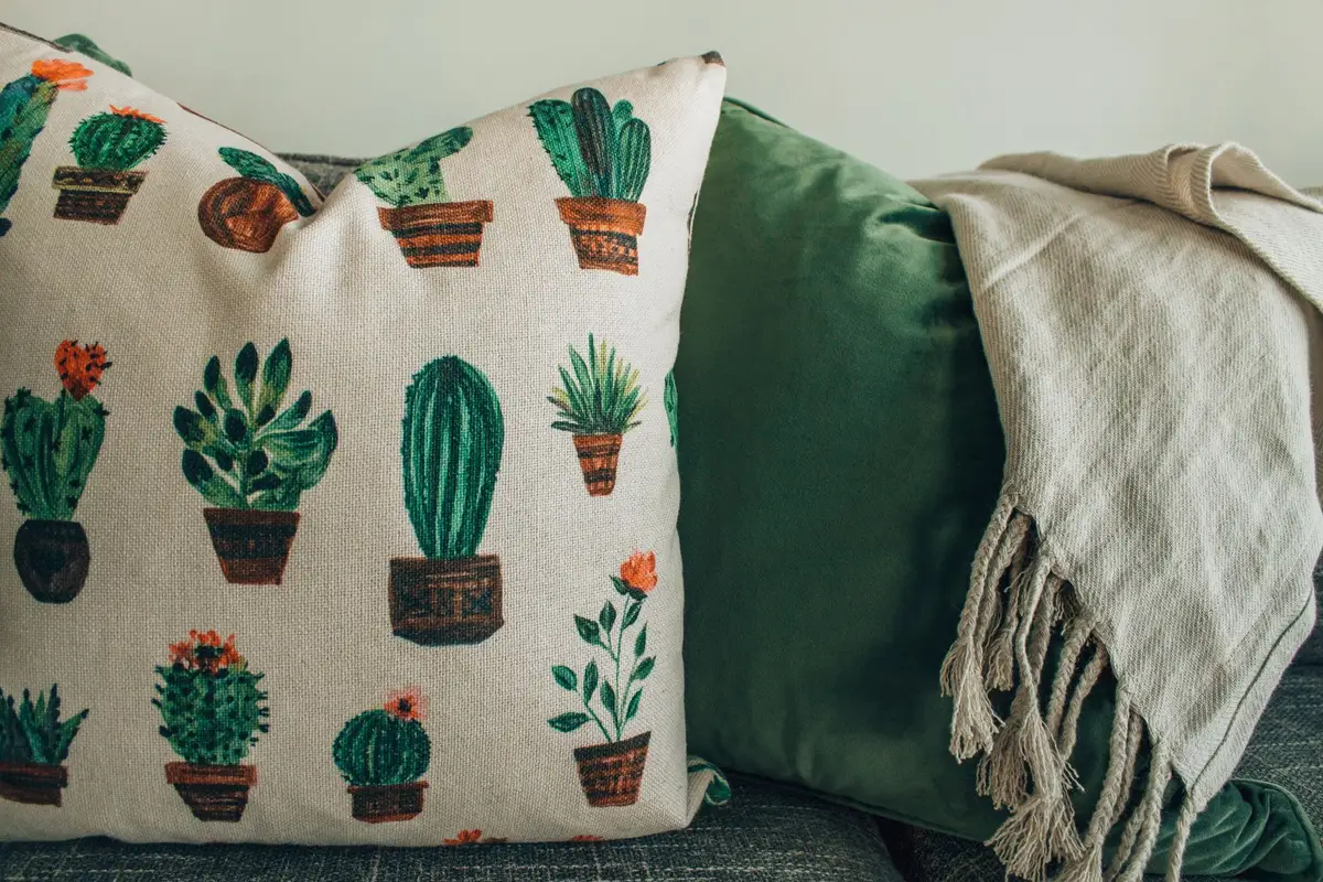 Espace intérieur avec plantes à différentes hauteurs, tapis et coussins en matières naturelles