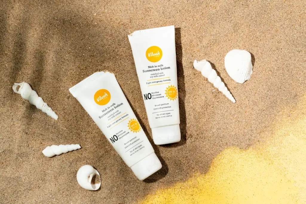 Flacons de crème solaire avec étiquettes SPF alignés sur un rayon de supermarché éclairé par la lumière naturelle