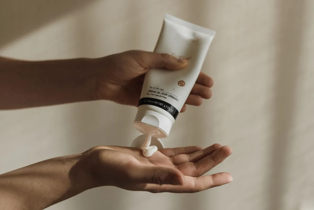 Application d'une crème hydratante riche sur les talons et la plante des pieds.