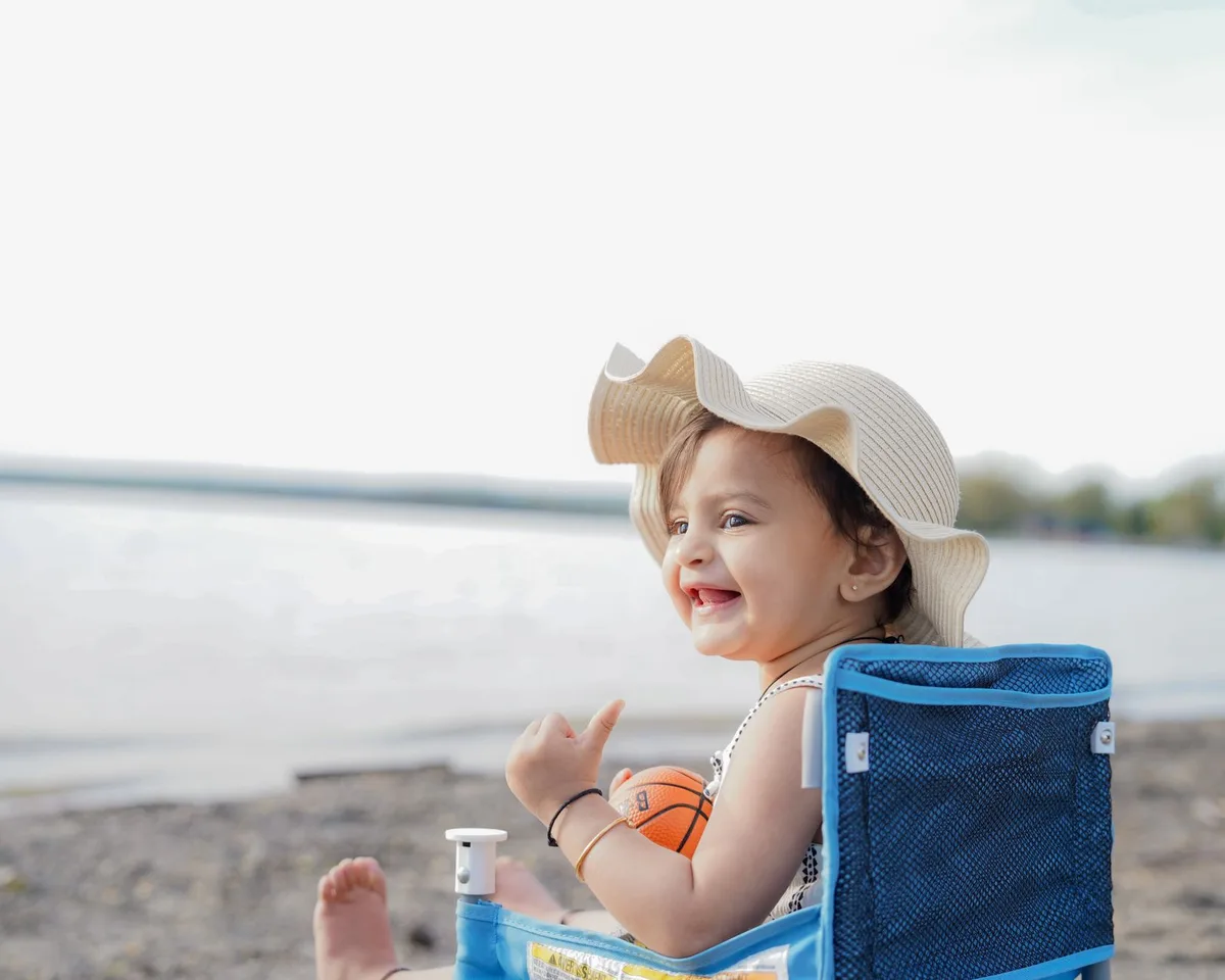Enfant portant un chapeau et des vêtements de protection au soleil à la plage