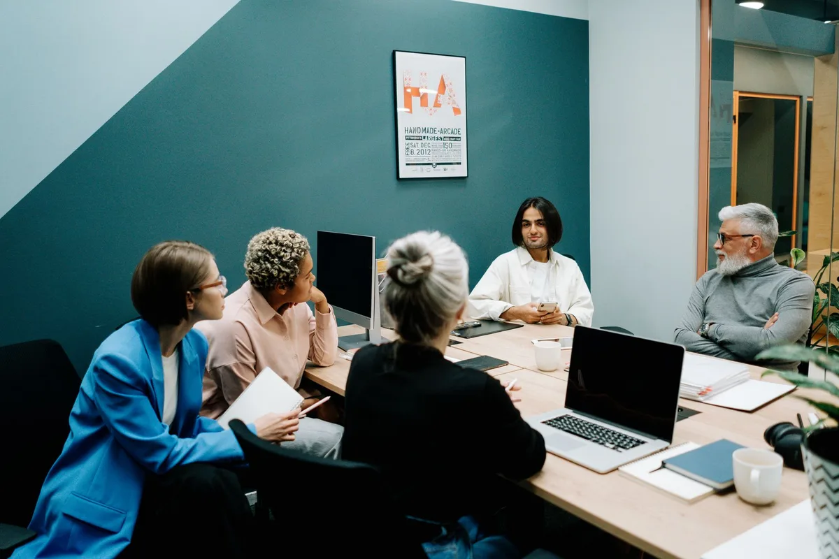 Groupe de professionnels en réunion discutant et écoutant activement, montrant une communication transparente en équipe.