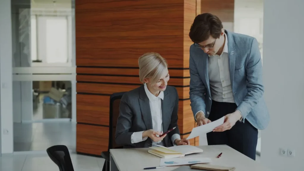 Personne réfléchissant à son bureau avec documents et notes, représentant la remise en question d'une opinion.