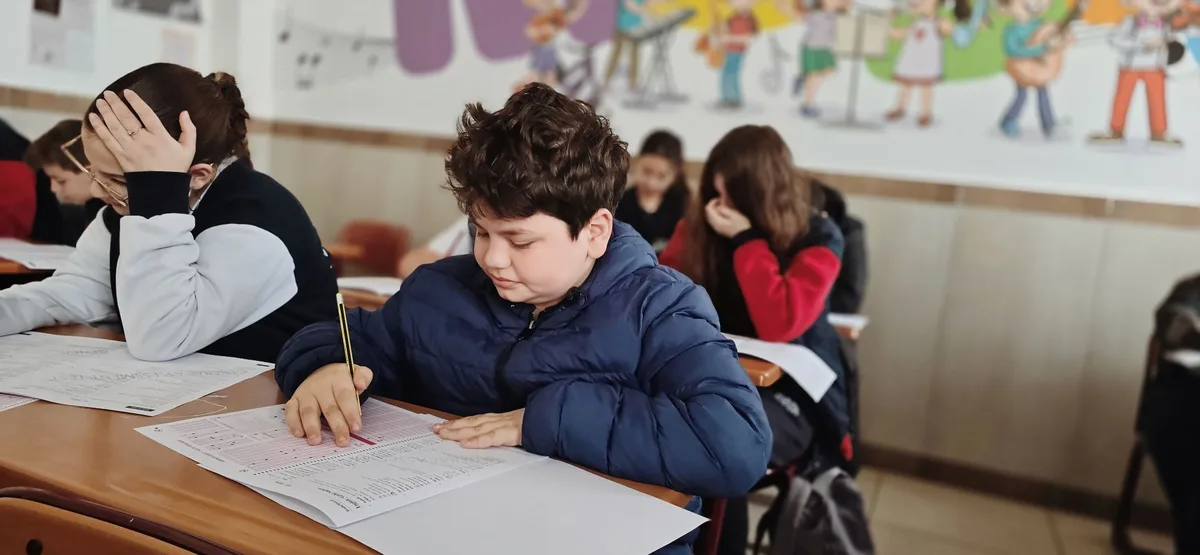 Élève concentré en classe, levant la main pour participer