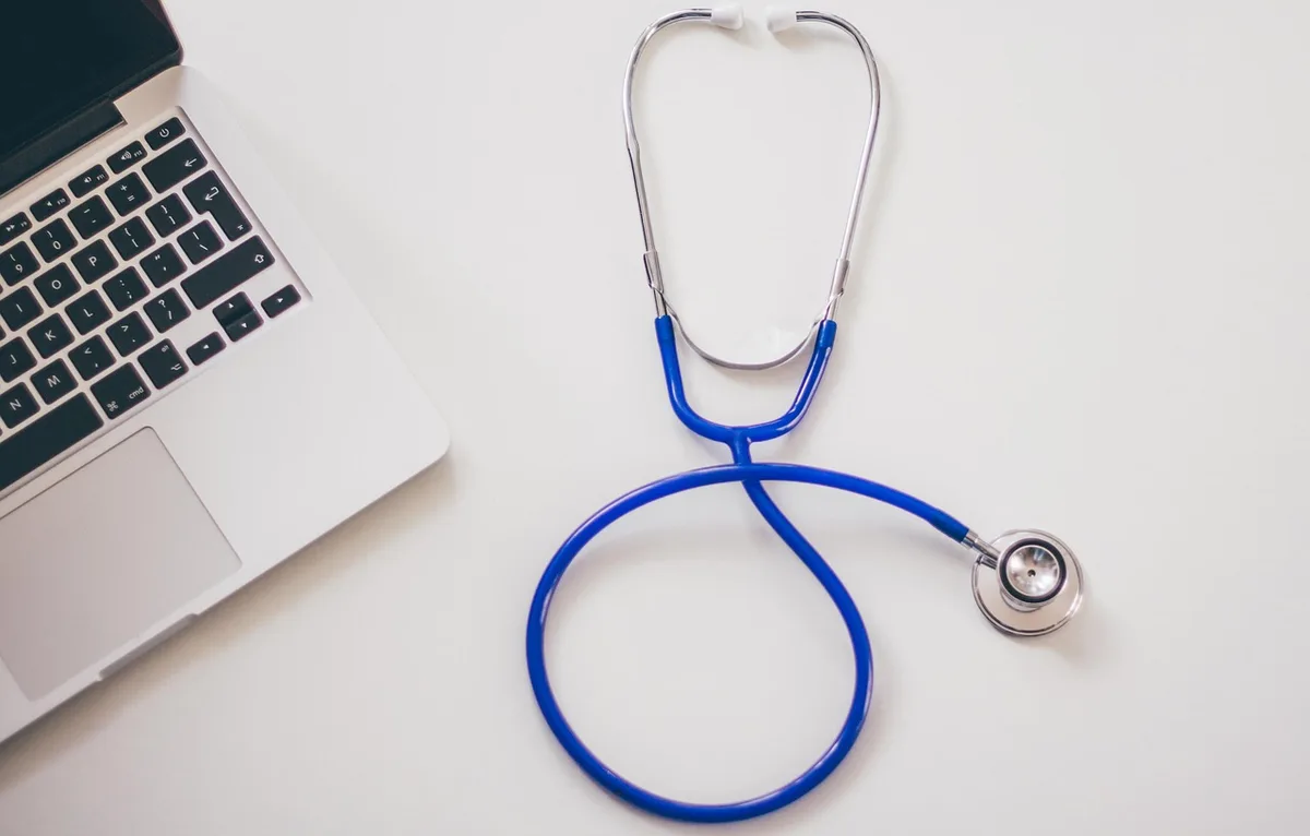 Dossier médical et stéthoscope sur un bureau de consultation, symbolisant l'examen des antécédents médicaux.