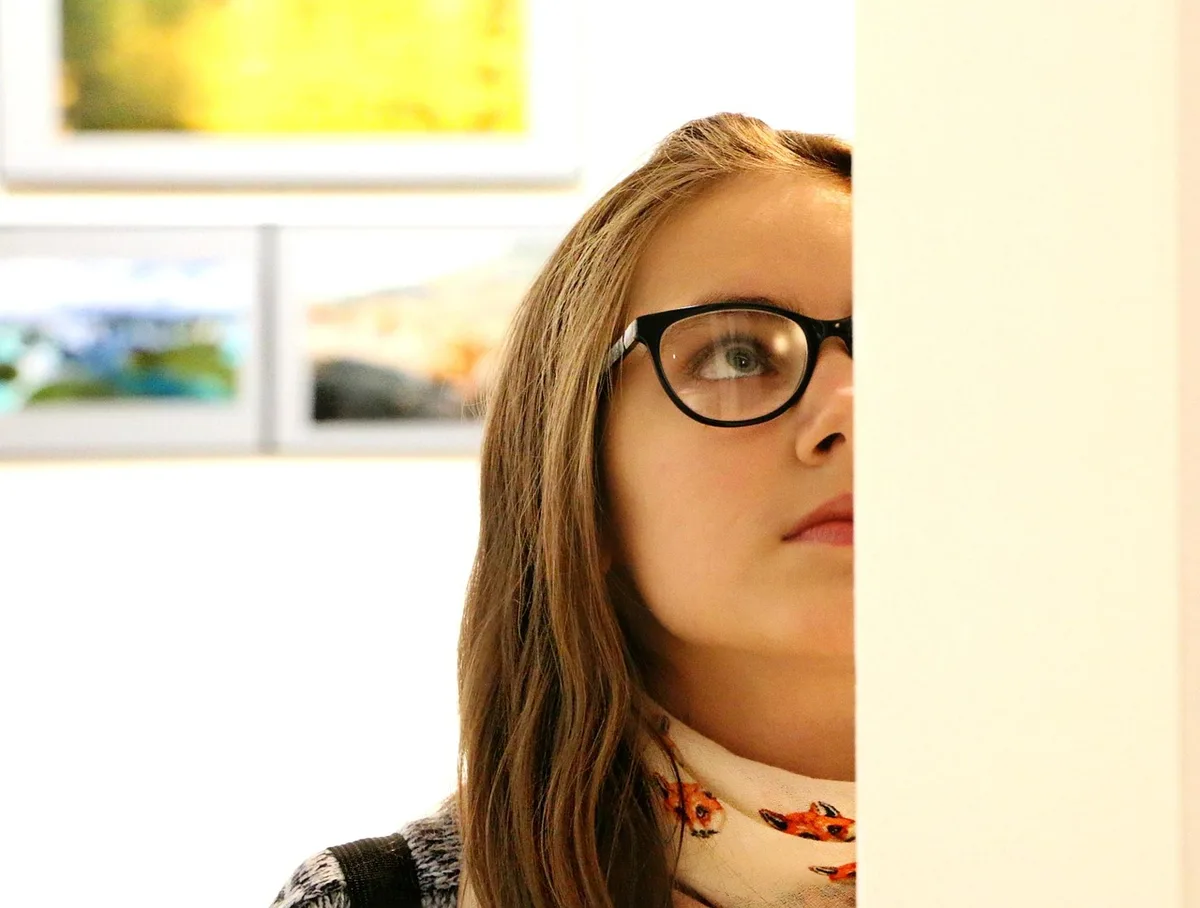 Personnes anonymes visitant une galerie lumineuse avec œuvres exposées