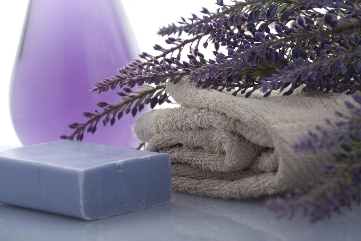 Personne sous le jet de la douche, eau chaude coulant, salle de bain bien éclairée