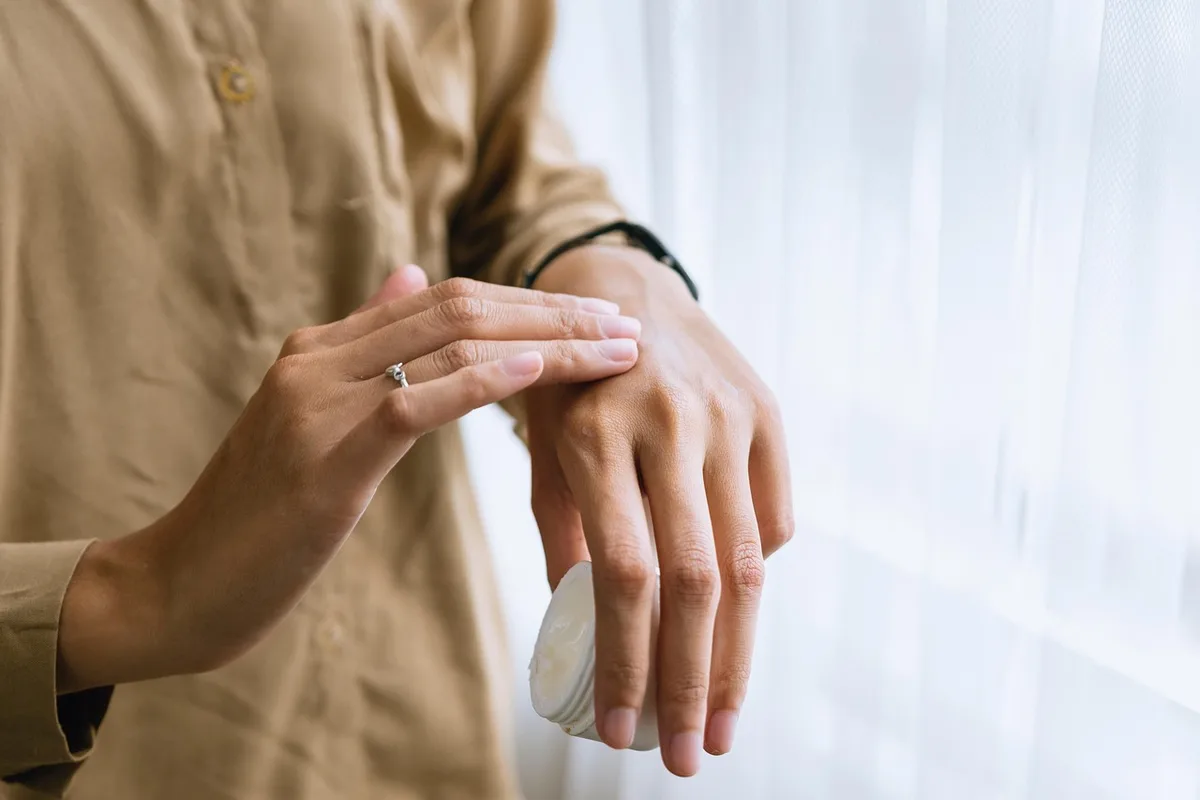 Femme prenant une douche tiède avec des produits de soin doux