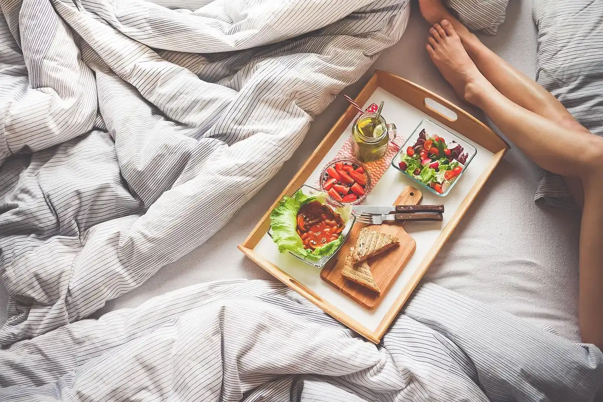 Personne avec écouteurs allongée sur un lit dans une chambre calme