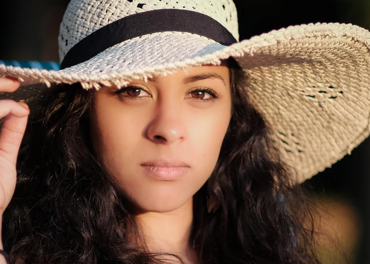 Famille à la plage avec chapeau, vêtements couvrants et crème solaire pour une protection complète