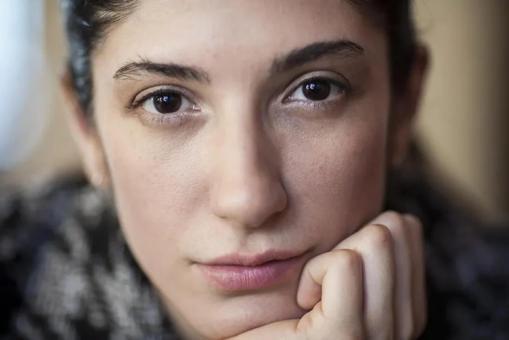 Femme d'âge mûr appliquant une crème hydratante sur son visage le matin