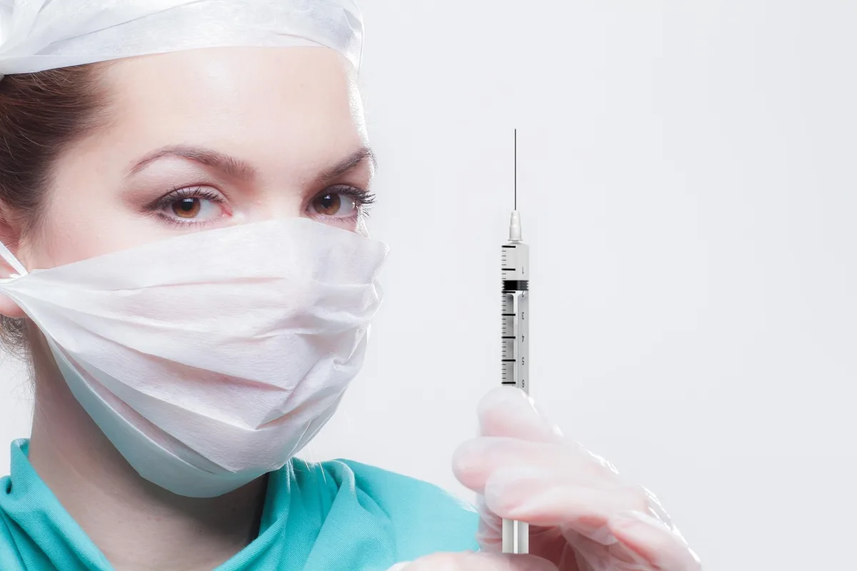 Infirmière administrant une injection dans le bras d'un patient en journée