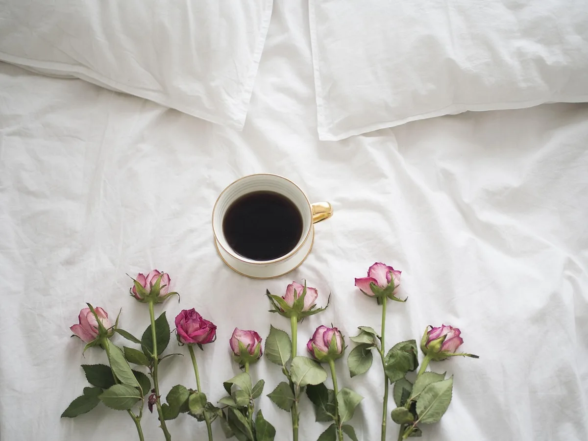 Allongé sur le dos dans le lit, bras allongés vers la tête pour un étirement matinal