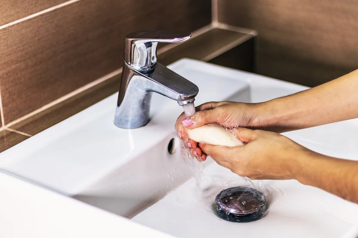 Application de crème sur les pieds avec chaussettes fines à côté
