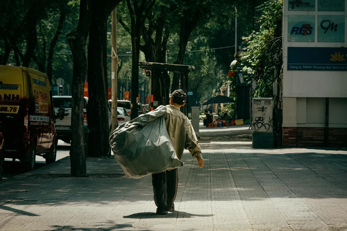 Personne marchant dans une rue urbaine en plein jour avec un sac à dos léger