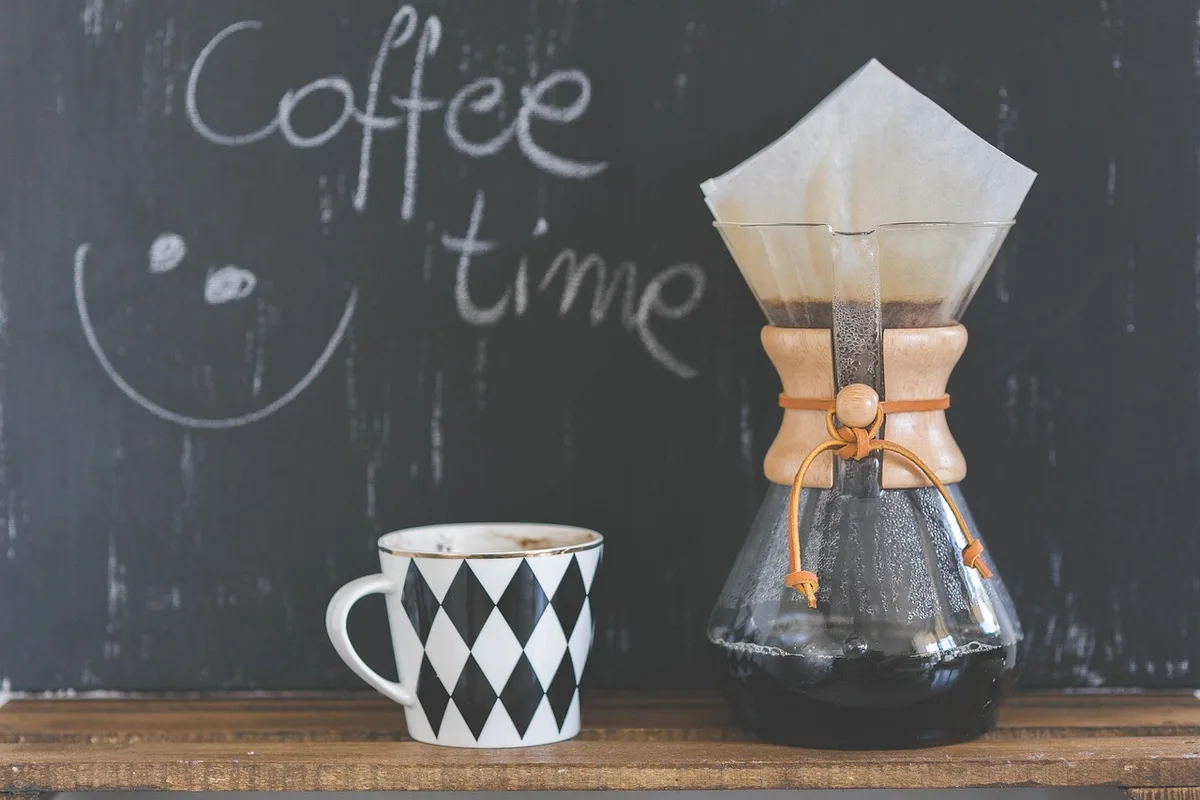 Tasse de café posée près d'agrumes et d'épices sur un plan de travail