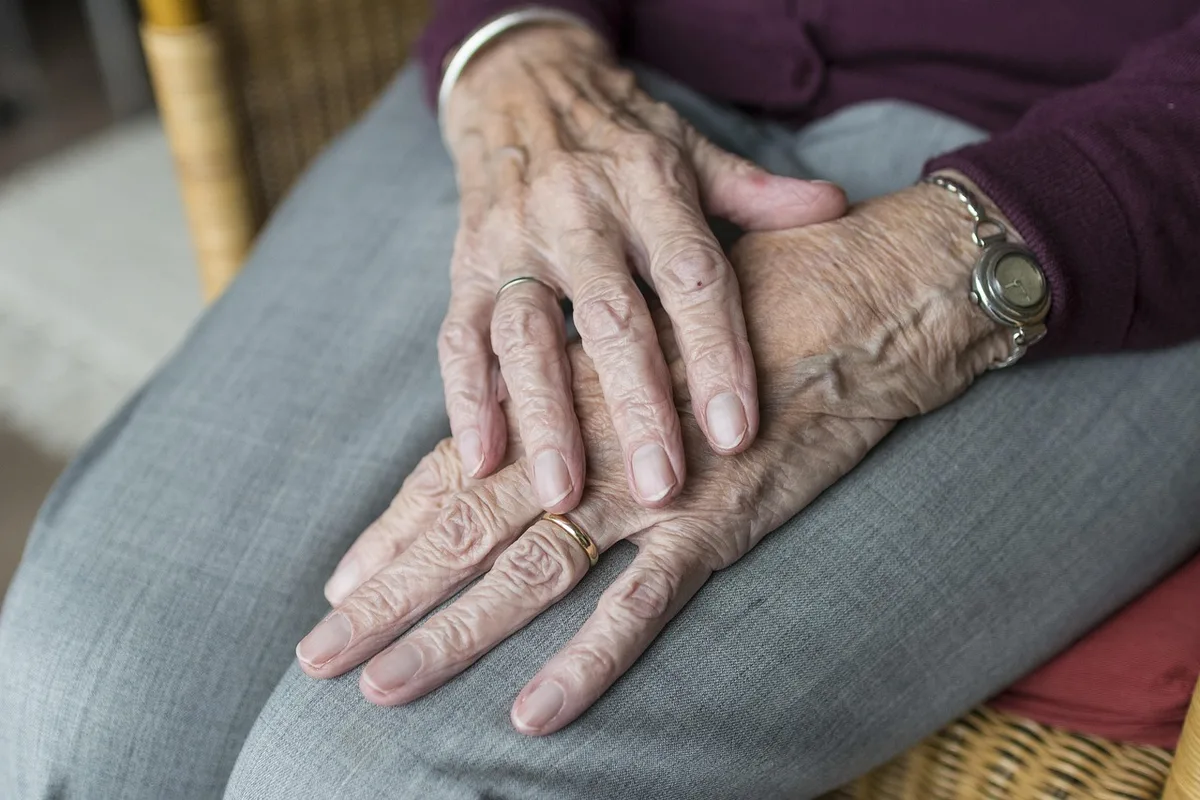 Mains d'une personne massant sa paume pour se recentrer